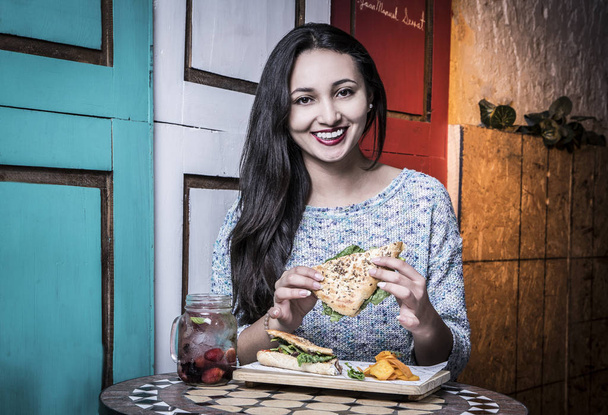 Beautiful woman with smile, eating at old restaurants - Photo, Image