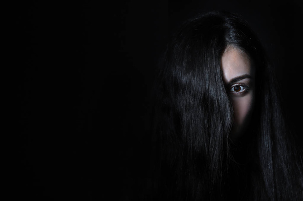 Közelkép egy lány haj borított haj Fekete háttér - Fotó, kép
