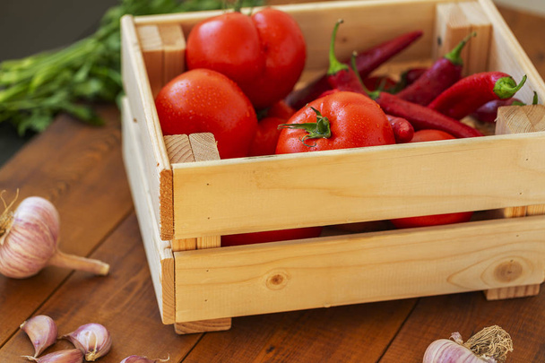 Свежие овощи в деревянной коробке на фоне дерева - Фото, изображение