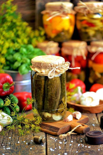 Soğan, sarımsak, biber ve eski bir ahşap zemin üzerinde bir kavanoza horseradish ile ev yapımı salatalık turşusu. - Fotoğraf, Görsel