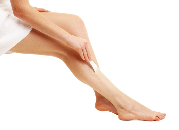 Hermosas piernas de mujer con crema depilación, aislado en blanco
 - Foto, Imagen