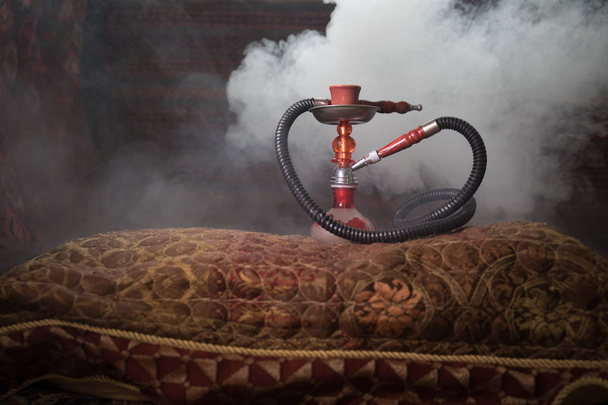 Кальян розпеченим на Шиша чаші робить хмари пари в арабській інтер'єру. Східний орнамент на килимі. Стильний Східні Шиша з підсвічуванням. За реклами Шиша. Вибірковий фокус - Фото, зображення