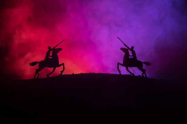 Світова війна (або воїн) вершник на коні з мечем, готовим битися, а солдати на темному туманному тонованому тлі. Бойова сцена поля битви солдатів. Вибірковий фокус
 - Фото, зображення