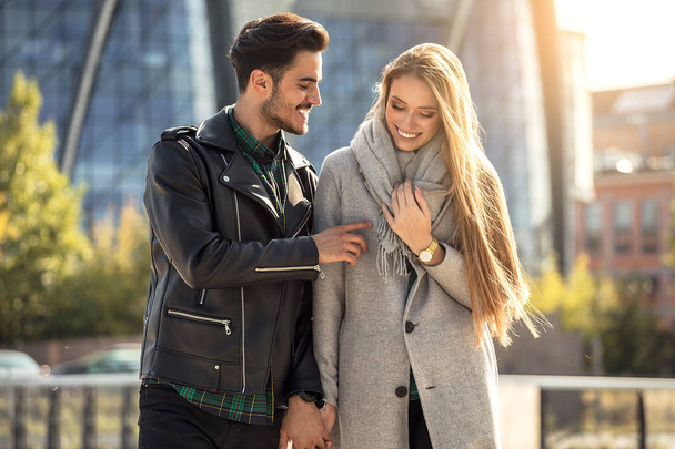 Young couple dating in the city. Blonde beautful woman and handsome man in fashionable clothes , autumn season. - Photo, image