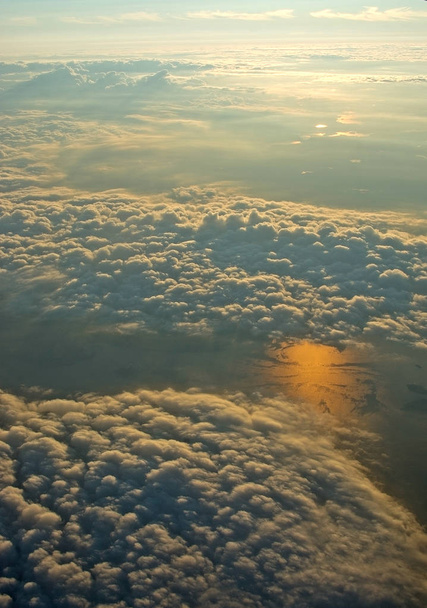 Vista aérea abstracta del paisaje sobre las nubes y el reflejo del sol en el agua al atardecer en una noche de verano cerca de Estocolmo, Suecia
. - Foto, imagen