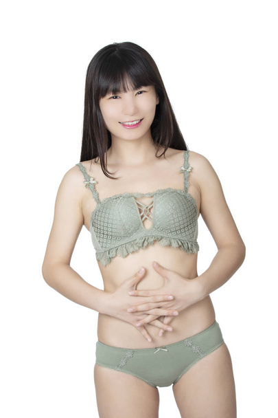 Beautiful Chinese woman posing in a pair of green panties and bra isolated on a white background. panties and bra isolated on a white background. - 写真・画像