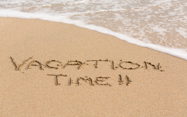 Tiempo de vacaciones escrito en arena con surf de mar
 - Foto, Imagen