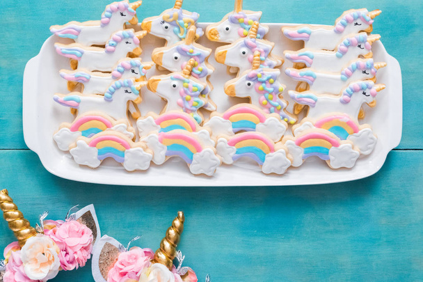 Galletas de azúcar unicornio decoradas con glaseado real sobre un fondo azul
. - Foto, imagen