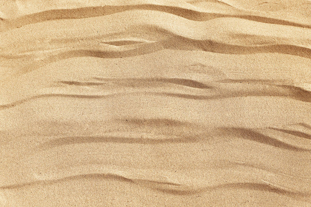 Sandy beach on a sunny day, background. Yellow, beige, soft sand. Wavy texture Top view - Photo, Image