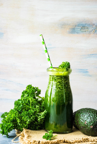 Organic and healthy green smoothie with banana, spinach, avocado, citrus fruits and chia seeds in a glass bottles on a rustic background withcopy space - Fotoğraf, Görsel