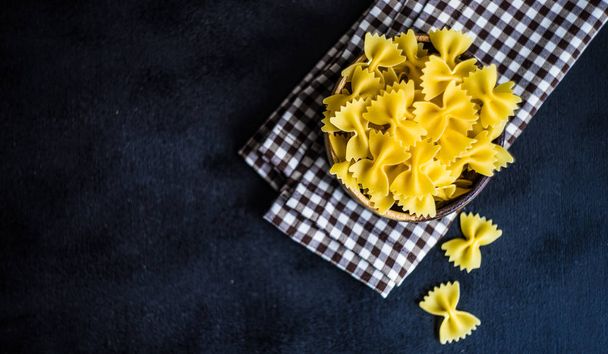 farfalle pasta in a bowl on rustic background with copy space - Fotoğraf, Görsel