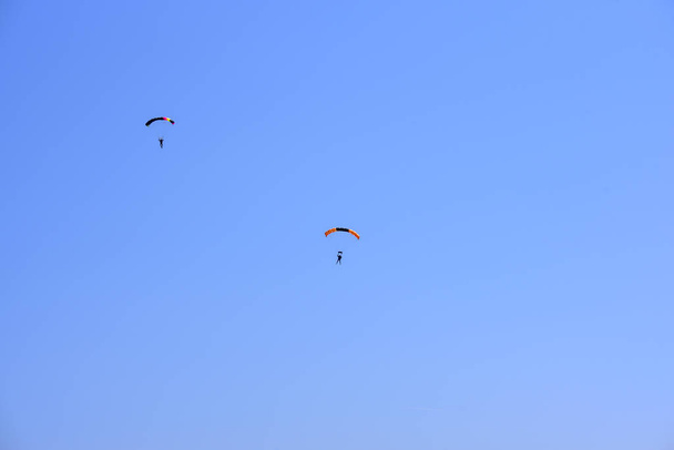 Deux parachutistes descendent contre un ciel bleu
 - Photo, image