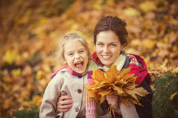 Mother and daughter in the autumn park - Фото, изображение