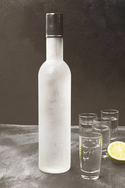 Cold vodka in shot glasses on a black background. Toned - Valokuva, kuva