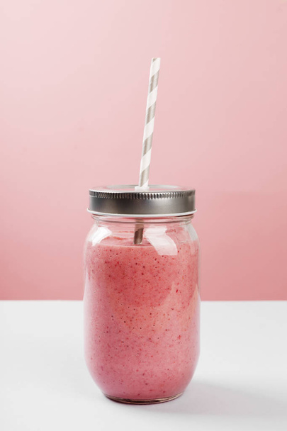 Strawberry smoothies on a pink background - Фото, зображення
