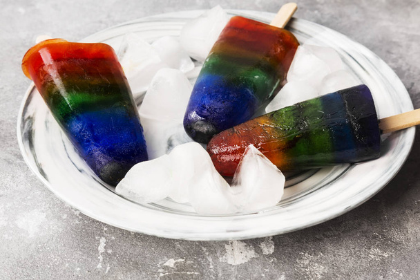 Rainbow ice cream popsicle on a gray background - Foto, afbeelding