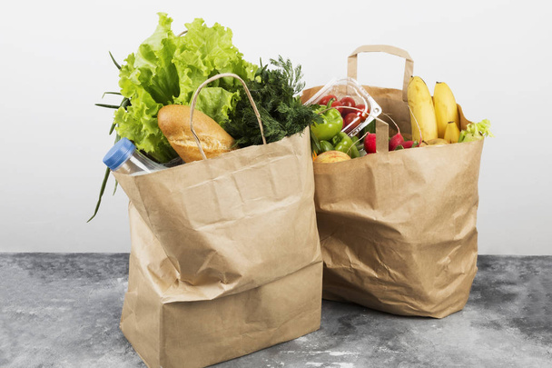 Various healthy food in paper bag on gray background - Fotó, kép