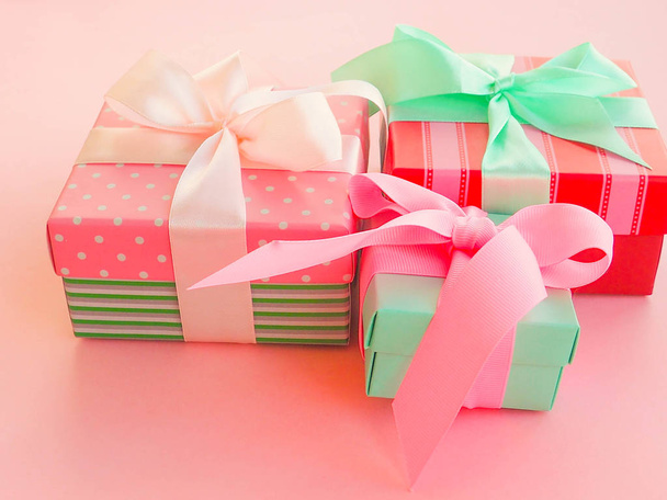 Розовый подарок на Рождество с лентой, на розовом фоне
. - Фото, изображение