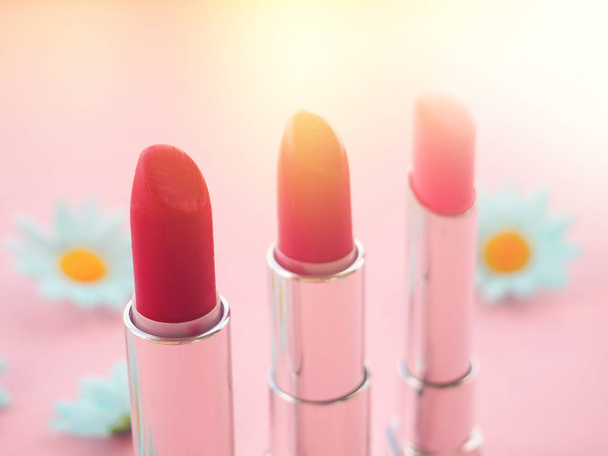 tres tubos de lápiz labial sobre fondo rosa, el concepto de belleza
. - Foto, Imagen