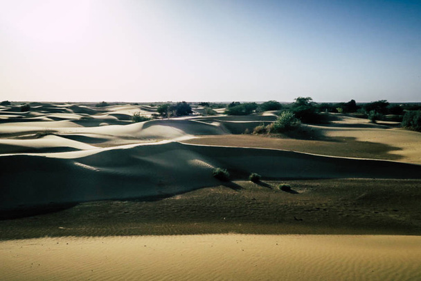Belo pôr do sol atrás de dunas de areia com caravane de camelo em uma expedição ao deserto
 - Foto, Imagem