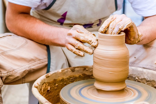 Close-up beeld van een kunstenaar van de mannelijke aardewerk klei pot maken in een workshop - Foto, afbeelding