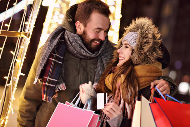 大人のカップルがクリスマスの時間の間に都市のショッピング - 写真・画像