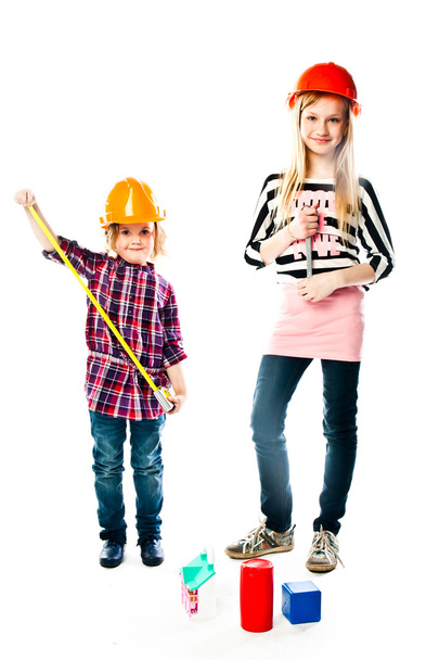 Two girls in construction helmets - Фото, изображение