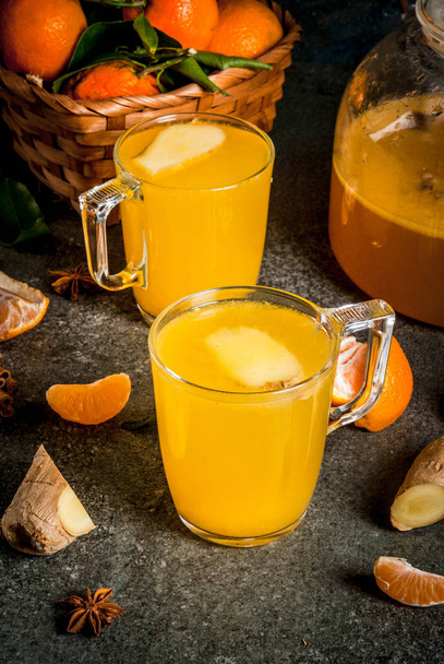 Tangerine Ginger Tea with cinnamon and anise, with ingredients, on dark stone background, copy space  - Fotografie, Obrázek