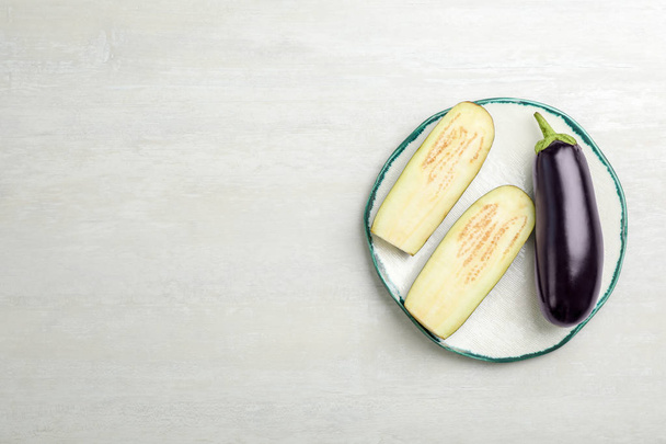Plate with ripe eggplants on light background, top view - Foto, Imagem
