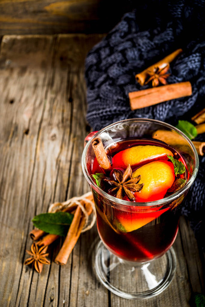 Classic winter autumn hot drink, mulled wine cocktail with  spices, with plaid and Christmas tree branches, on a wooden background, copy space for text - Photo, Image