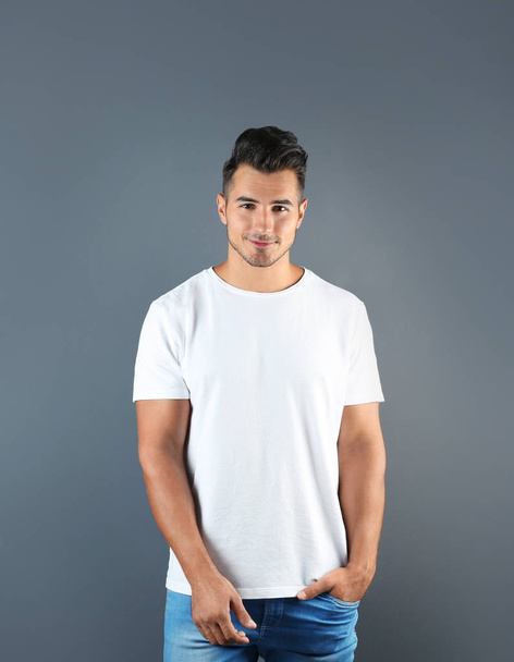 Young man in t-shirt on grey background. Mockup for design - Fotó, kép