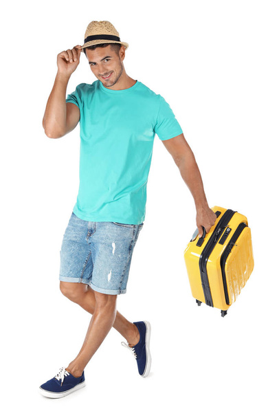 Young man walking with suitcase on white background - Φωτογραφία, εικόνα