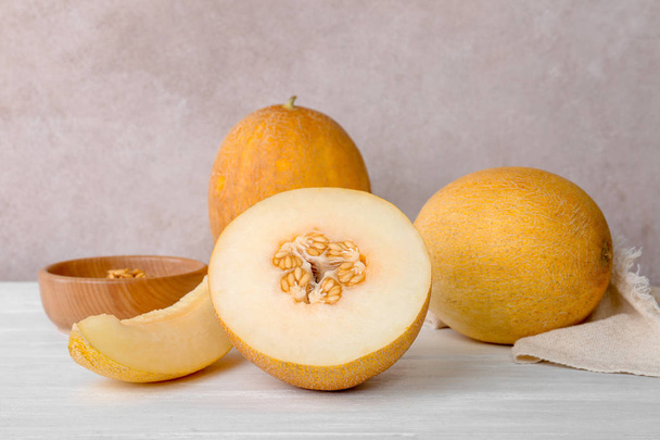 Fresh delicious sweet melons on table against color background - Φωτογραφία, εικόνα