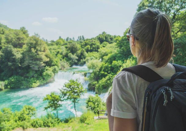 Touristin mit Rucksack blickt auf Wasserfälle. - Foto, Bild