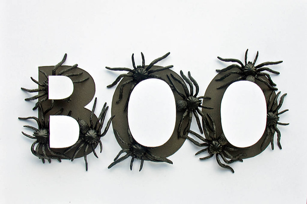 Giocattoli ragno nero in parola Boo su sfondo di carta bianca. Luminoso concetto di ottobre di Halloween. Vista dall'alto
 - Foto, immagini