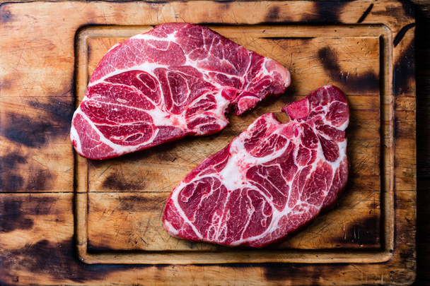 Raw marbled beef steaks on wooden cutting board. Top view - Foto, imagen