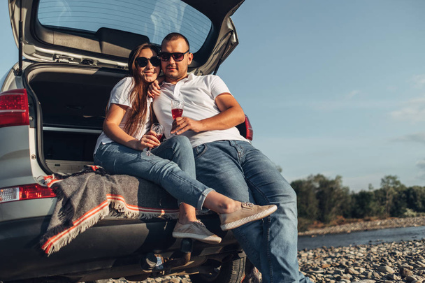 Felice coppia viaggiatore su Picnic nel tramonto con SUV auto
 - Foto, immagini