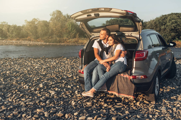 Happy Couple on Roadtrip into the Sunset in SUV Car - Photo, Image