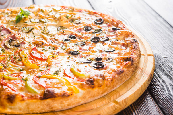 Pizza  on a dark wooden background with fresh vegetables  - Foto, imagen
