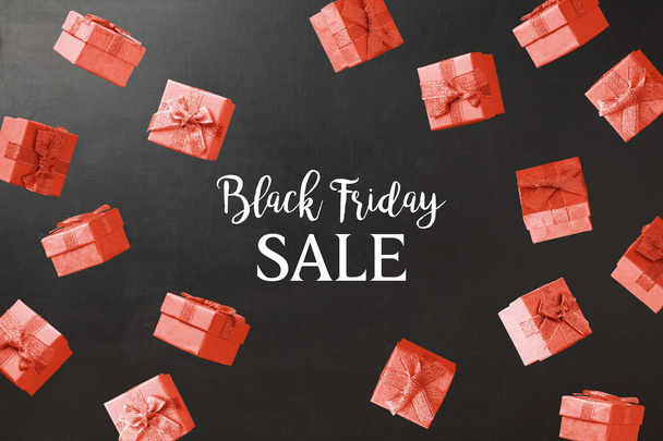 Black Friday sale concept with red gift boxes flying over blackboard background - Φωτογραφία, εικόνα