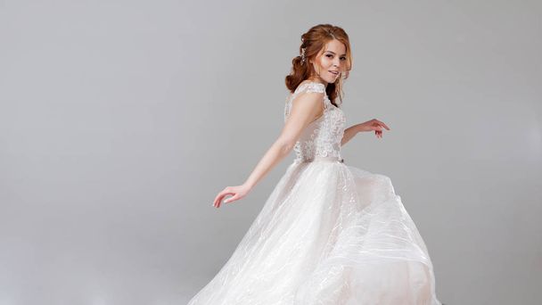 Lovely young woman bride in lavish wedding dress. Light background. - Foto, Imagem