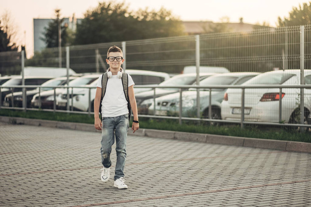 Портрет мальчика, слушающего музыку в наушниках на улице
 - Фото, изображение