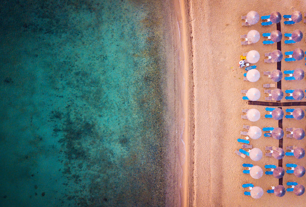 Пляж с пумбреллами и сандалиями, создающими панорамный вид
 - Фото, изображение
