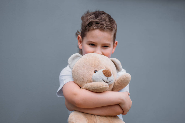 Safety concept. The boy is holding teddy bear - Foto, imagen
