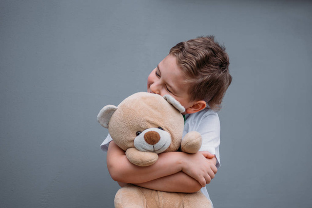 Safety concept. The boy is holding teddy bear - Foto, afbeelding
