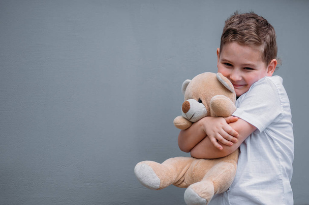 Safety concept. The boy is holding teddy bear plase for text - Foto, Imagem