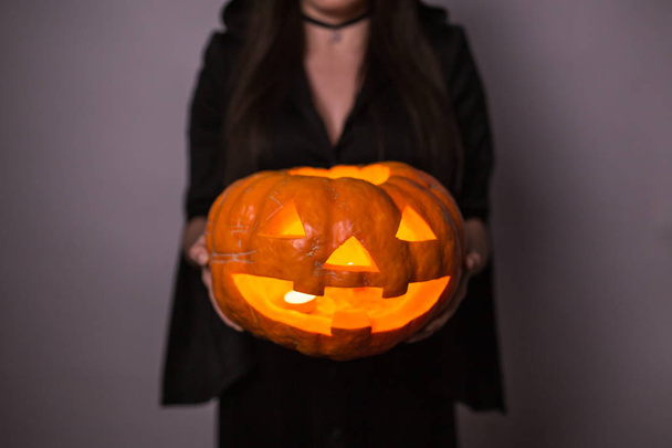 Jack o Lanterna Halloween abóbora sorrindo da maneira mais má nas mãos das mulheres
 - Foto, Imagem
