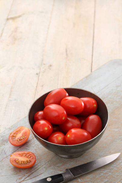voorbereiding van smakelijke plum tomatoes  - Foto, afbeelding