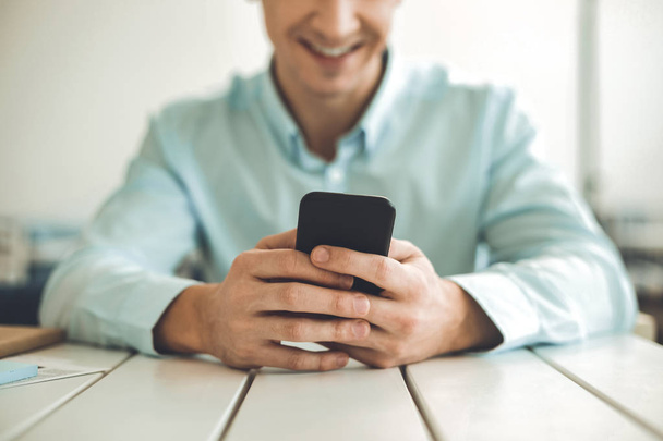 Close up of a modern smartphone in hands of smiling man - Foto, Imagen