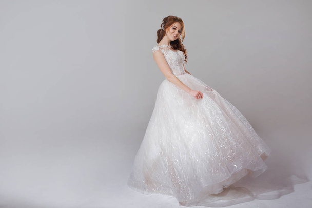 Lovely young woman bride in lavish wedding dress. Light background. - Fotoğraf, Görsel